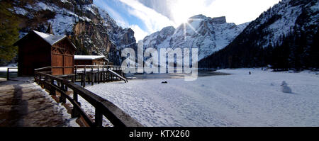 Coucher de soleil, avec une belle réflexion, derrière le lac de Braies, encadré par les montagnes couvertes de neige et le ciel bleu Banque D'Images