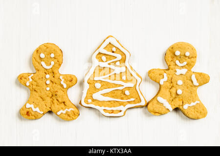 Gingerbread men amis de l'arbre de Noël sur une table en bois blanc Banque D'Images