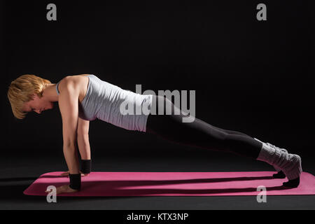 Young woman practicing yoga, Chaturanga Dandasana / Four-Limbed posent le personnel Banque D'Images