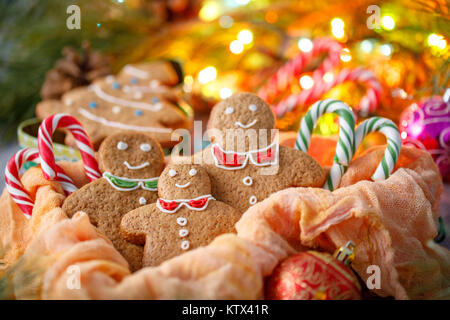 La vie toujours avec les cookies sous la forme de petites gens et les arbres de Noël sur l'arrière-plan d'une guirlande. Fête de la famille la nouvelle année Banque D'Images