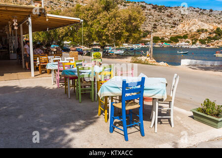 ZAKYNTHOS, GRÈCE - 27 septembre 2017 : Tables avec chaises colorées en taverne grecque en port d'Agios Nikolaos sur côte nord-est de l'isl de Zakynthos Banque D'Images