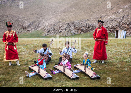 Des garçons jouent à Morin-khuur (instrument à cordes) (violon à tête de cheval) alors que les jeunes filles jouent Yatga-Yatuga (instrument à cordes), Bunkhan, la Mongolie, le Centr Banque D'Images