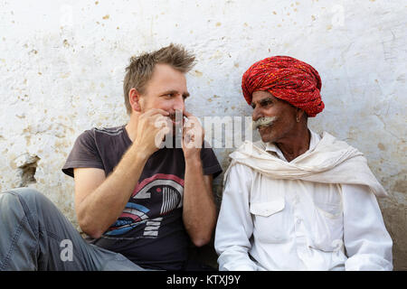 Un homme de race blanche et de l'Inde montrant big moustache à l'autre, village près de Pushkar, Rajasthan, Inde. Banque D'Images