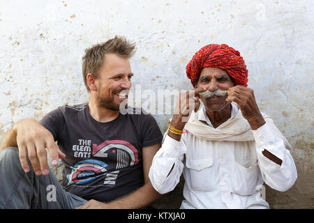 Un homme de race blanche et de l'Inde montrant big moustache à l'autre, village près de Pushkar, Rajasthan, Inde. Banque D'Images