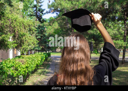 Le jour de la remise des diplômes, des images de diplômés célèbrent leur diplôme mis de main, un certificat et un chapeau à la main. Date d'exécution, félicitations. Banque D'Images