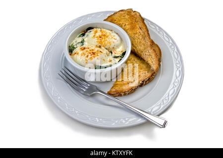 Oeufs Florentine avec oeufs pochés sur un lit d'épinards flétries garni de sauce hollandaise et saupoudré de Paprika Banque D'Images