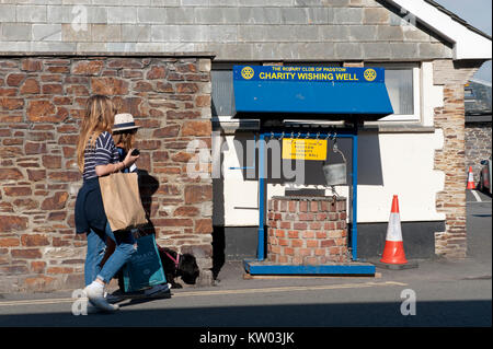 Deux jeunes femmes et un chien devant une charité point de collecte à Padstow Cornwall UK Banque D'Images