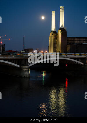 Londres, Angleterre, Royaume-Uni - 20 août 2013 : l'emblématique cheminées de la Battersea Power Station à l'abandon à éclairé la nuit en face d'une lune brillante, comme au Sud Banque D'Images