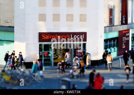 Un magasin Sainsbury's au centre d'une ville animée. Le quartier est occupé avec les consommateurs et le logo de l'entreprise est clairement visible. Tourné en minature Banque D'Images
