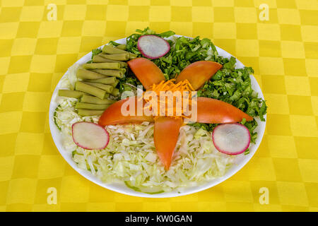 Un plat blanc servi avec tomate, chou, haricots, radis, la laitue et la carotte Banque D'Images