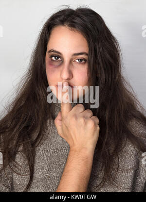 Un homme violent silence une femme avec un œil meurtri noir avec sa main dans un concept de violence domestique Banque D'Images