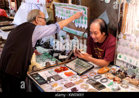 Contrôle de l'opérateur de Jade son smart phone, Marché de Jade, Yau Ma Tei, Kowloon, Hong Kong, Chine Banque D'Images