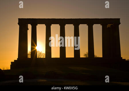 Rising Sun flares à travers les colonnes du Monument National à Édimbourg, Écosse Banque D'Images