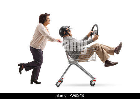 Homme mature avec un casque et un cheval volant à l'intérieur d'un panier qui est poussé par une femme âgée isolé sur fond blanc Banque D'Images