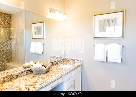 Serviettes de main en panier tressé avec comptoir en granit dans la salle de bains lavabo et miroir dans la maison ou de l'appartement modèle de rassemblement, de réflexion de douche Banque D'Images