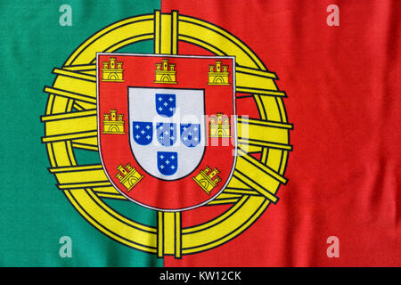 Un drapeau portugais est illustrée comme il se pose sur une surface plane. Les armoiries dans entre les couleurs vert et rouge en gras est un grand symbole pour le pays Banque D'Images