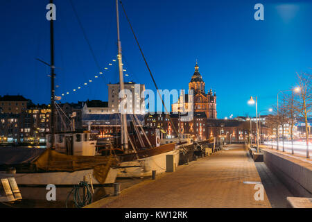 Helsinki, Finlande. Pier avec bateaux, Pohjoisranta Street et vue sur la cathédrale Uspenski En Soir Nuit Illuminations. Banque D'Images