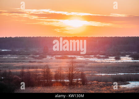 Beau Lever de soleil sur la rivière et la forêt au début du printemps. Ciel dramatique avec plus de soleil matin Nature. Banque D'Images