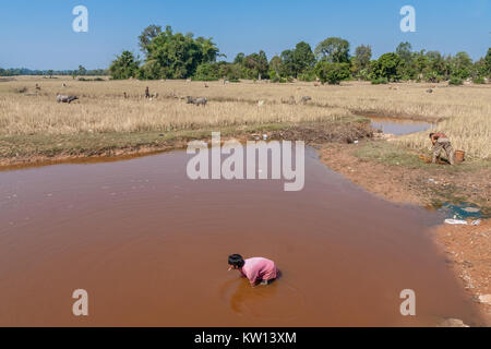 Un jeune homme khmer dans un étang de pêche Banque D'Images