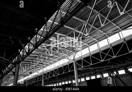 Image en noir et blanc de la complexité des accolades métalliques soutenant le toit de Pier 48, un hangar, un ancien hangar de stockage au Port de San Francisco, maintenant utilisé comme un terrain de stationnement, San Francisco, Californie, 2016. Banque D'Images