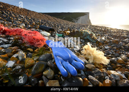 Plastique et déchets rejetés sur une plage près de l'emblématique sept Sœurs des falaises de craie dans le sud de l'Angleterre, Cuckmere Haven, East Sussex, UK. Banque D'Images