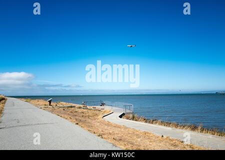 Avion volant bas en approche sur l'Aéroport International de San Francisco, à San Francisco Bay visibles, Seal Point Park, San Mateo, Californie, juillet 2016. Banque D'Images