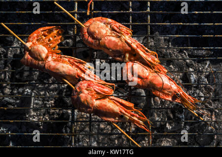 Fruits de mer crevettes barbecue grillé sur la cuisinière, de l'alimentation. Langoustines en coque, frits dans l'incendie. Banque D'Images