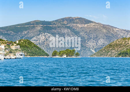 L'îlot Lazareto, dans la mer Ionienne près de Vithy, Ithaca, avec ses arbres et église orthodoxe grecque peint en blanc, sur une colline boisée à l'arrière Banque D'Images