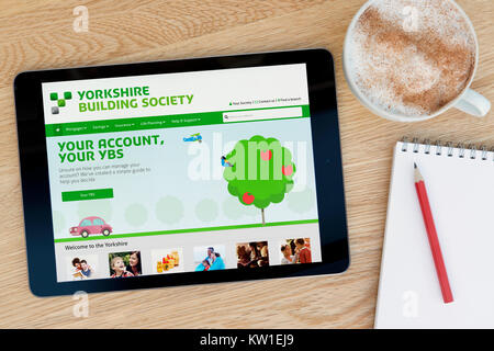 Le Yorkshire Building Society site sur un iPad tablet device, reposant sur une table en bois à côté d'un bloc-notes, crayon et tasse de café (rédaction uniquement) Banque D'Images