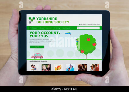 Un homme regarde les Yorkshire Building Society site sur son iPad tablet device, tourné contre une table en bois page contexte (usage éditorial uniquement) Banque D'Images