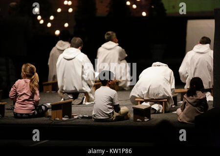 Bâle, Suisse. 28 Dec, 2017. Les frères de Taizé s'asseoir sur le sol en face de l'autel. Autour de 20 000 pèlerins de l'Europe et au-delà se sont réunis à Bâle en Suisse pour la réunion européenne de la jeunesse de la communauté de Taizé sur le thème Le Pèlerinage de confiance sur la terre". La communauté de Taizé est un ordre monastique chrétien interconfessionnel de la France. Crédit : Michael Debets/Alamy Live News Banque D'Images