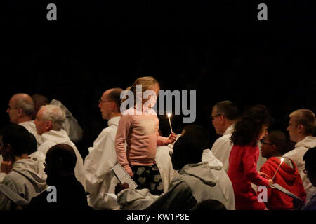 Bâle, Suisse. 28 Dec, 2017. Un enfant revient avec une bougie allumée à partir de l'autel. Autour de 20 000 pèlerins de l'Europe et au-delà se sont réunis à Bâle en Suisse pour la réunion européenne de la jeunesse de la communauté de Taizé sur le thème Le Pèlerinage de confiance sur la terre". La communauté de Taizé est un ordre monastique chrétien interconfessionnel de la France. Crédit : Michael Debets/Alamy Live News Banque D'Images