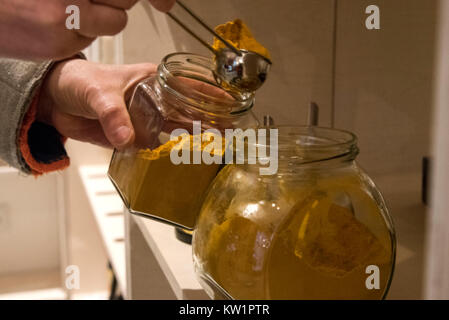 Munich, Allemagne. Dec 18, 2017. Un client se remplit son propre verre avec des épices dans le magasin 'Ohne' (allemand : Sans) à Munich, Allemagne, 18 décembre 2017. Les légumes et les fruits dans des caisses en bois, des céréales et du riz dans des contenants en verre, papier toilette et des préservatifs que emballé avec du papier : Package gratuitement les supermarchés sont tendances. Credit : Amelie Geiger/dpa/Alamy Live News Banque D'Images