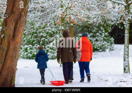 Glasgow, Ecosse, Royaume-Uni. 29 décembre 2017. Météo France : Le Met Office émet un avertissement jaune comme un épais manteau de neige recouvre la ville de Glasgow. Une famille de marcher dans la neige et en tirant un traîneau. Credit : Skully/Alamy Live News Banque D'Images