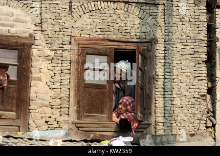 Srinagar, au Cachemire. 30 Décembre, 2017. La famille musulmane du cachemire regardent à la fenêtre comme un clerc (non visible sur la photo affiche une relique sainte .le urs annuel de Hazrat Sheikh Abdul Qadir Jeelani, populairement connu comme Ghous-ul-Azam, Dastageer Sahib, 11e siècle, saint, a été célébrée le samedi avec ferveur religieuse et de la gaîté dans la vallée du Cachemire.Malgré les conditions climatiques froides, des milliers de personnes, dont des femmes et des enfants, ont participé à la nuit de prières spéciales à des sanctuaires. Credit : Sofi Suhail/Alamy Live News Banque D'Images