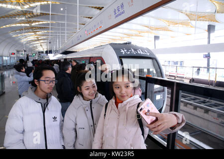 Beijing, Chine. Dec 30, 2017. Prendre des passagers en selfies avant d'un train sur la ligne S1 à Beijing, capitale de la Chine, 30 décembre 2017. 10,2 km de la ligne S1 est le premier Pékin moyen-faible débit ligne maglev. Il relie la banlieue ouest de Mentougou Shijingshan et districts. Trois autres lignes de métro, qui sont Yanfang Line, ligne S1 et de l'Ouest, ligne de banlieue l'exploitation a commencé à Pékin samedi, ce qui porte la longueur totale de métros de la capitale chinoise à 608 kilomètres. Crédit : Chen Xiaogen/Xinhua/Alamy Live News Banque D'Images