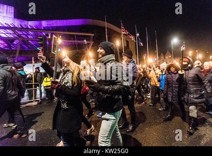 Edinburgh, Royaume-Uni. Dec 30, 2017. Edinburgh Hogmanay du début des célébrations avec la traditionnelle procession aux flambeaux. Cette année, la route se termine à l'extérieur du Parlement écossais à Holyrood où un mot choisi par les jeunes de l'Écosse qui les rend fiers de vivre dans le pays se révèle par les milliers de porteurs. Sur la photo : La Bohème passant du parlement écossais du nourrisson au cours de la Procession aux flambeaux Credit : Riche de Dyson/Alamy Live News Banque D'Images