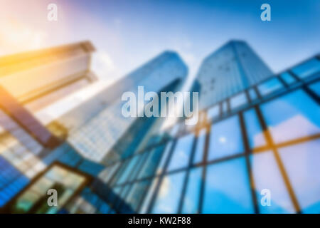 Résumé fond flou flou image de gratte-ciel modernes dans nouveau quartier d'affaires dans la belle lumière du soir au coucher du soleil avec des reflets effet du filtre Banque D'Images
