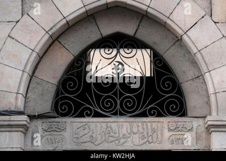 Une fenêtre supérieure semi-circulaire, avec une grille en fer stylisée avec un croissant ottoman et un symbole d'étoile avec une inscription arabe qui salue Allah et indique l'année de la construction, 1925 au-dessus de la porte d'une ancienne maison arabe située dans 24 rue Emek Refaim dans la colonie allemande ou HaMoshava HaGermanit un quartier établi dans la seconde moitié du 19ème siècle par des membres de la Société du Temple allemande et a été pendant l'ère de l'obligation britannique largement peuplée par Riches chrétiens arabes qui ont fui ou ont été expulsés pendant la guerre d'indépendance d'Israël de 1948. Jérusalem Ouest Israël Banque D'Images