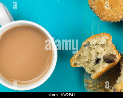 Muffins aux canneberges et bleuets avec une tasse de thé sur un fond bleu Banque D'Images