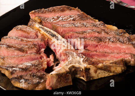 Tranches de t bone steak sur une plaque noire Banque D'Images