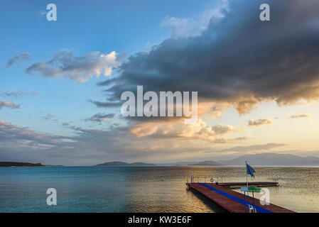 Lever du soleil avec des nuages sur un ciel bleu d'or sur une mer calme avec une jetée en bois en forme de L Banque D'Images