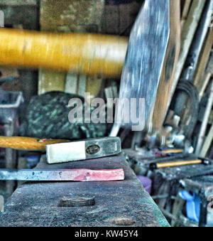 Cette image représente un marteau de forgeron utilisé sur du métal chaud au-dessus d'une enclume, représentant des techniques traditionnelles de forgeron. L'image met en évidence le savoir-faire et les compétences du travail des métaux, un métier qui fait partie intégrante de l'histoire de l'humanité depuis des siècles. Banque D'Images