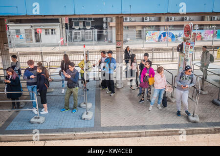 Les gens faire la queue à un arrêt de bus à hong kong Banque D'Images