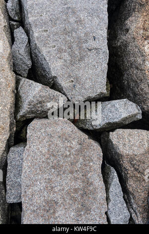 Regardant vers le bas sur un brise-lames de granit faites de grosses pierres Banque D'Images