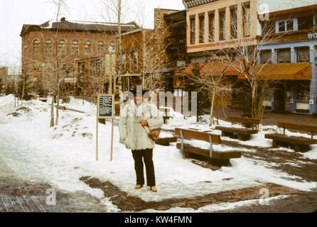 Femme portant un grand manteau de fourrure est à la Centre Commercial Aspen de Aspen, Colorado, 1975. Banque D'Images