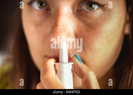 La fille utilise un spray pour le nez. Traitement du rhume, de la grippe Banque D'Images