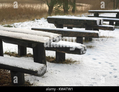 Bancs en bois et des tables couvertes de neige sur une rive du lac, scène d'hiver Banque D'Images