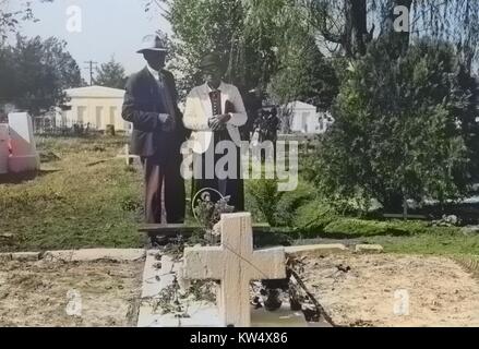 Couple afro-américaines à tombe d'un parent, la Toussaint au cimetière de nouvelles routes, Louisiane, 1940. Remarque : l'image a été colorisée numériquement à l'aide d'un processus moderne. Les couleurs peuvent ne pas être exacts à l'autre. Banque D'Images