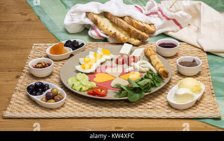 Portrait d'un petit-déjeuner turc traditionnel servi sur assiette de porcelaine avec fromage, salami, oeuf dur, tomate, concombre et pain grillé Banque D'Images